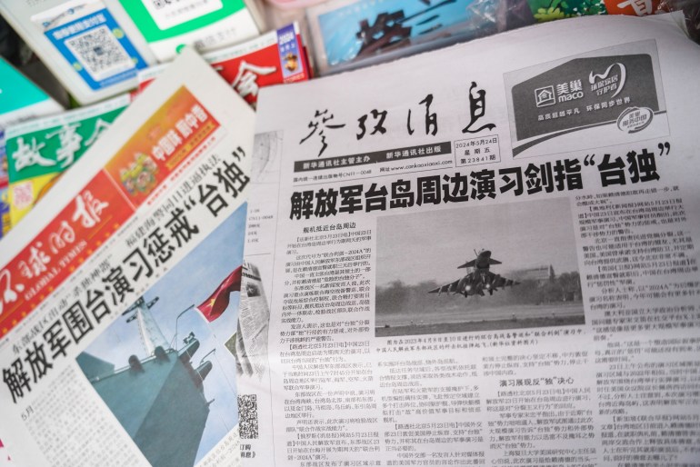 The front pages of Chinese newspapers reporting on the military drills around Taiwan. One has a picture of a fighter jet taking off. A second is showing a navy warship with a Chinese flag.