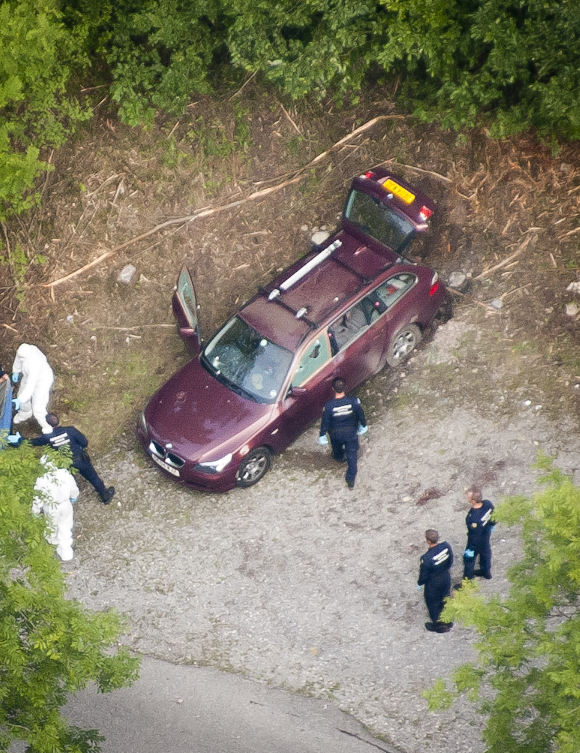 The BMW being investigated at the scene of the shooting in woods near Chevaline in the French Alps