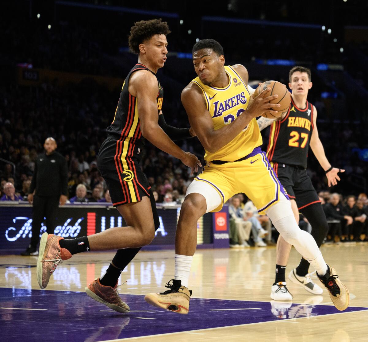 Lakers forward Rui Hachimura, right, drives to the basket against Hawks forward Jalen Johnson.