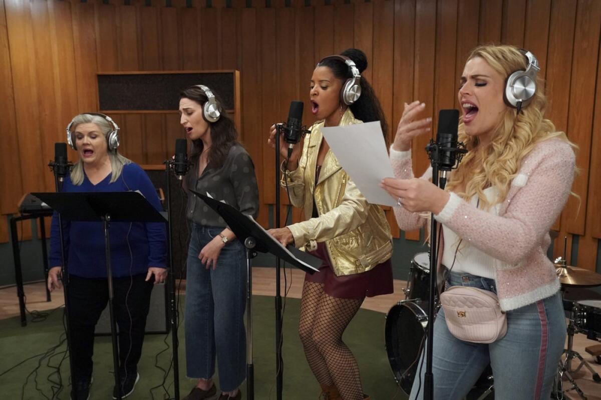Four women singing in a recording studio