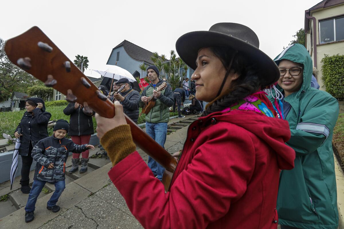 Protesters celebrate as a man and two women seize a vacant Caltrans-owned home in March 2020.