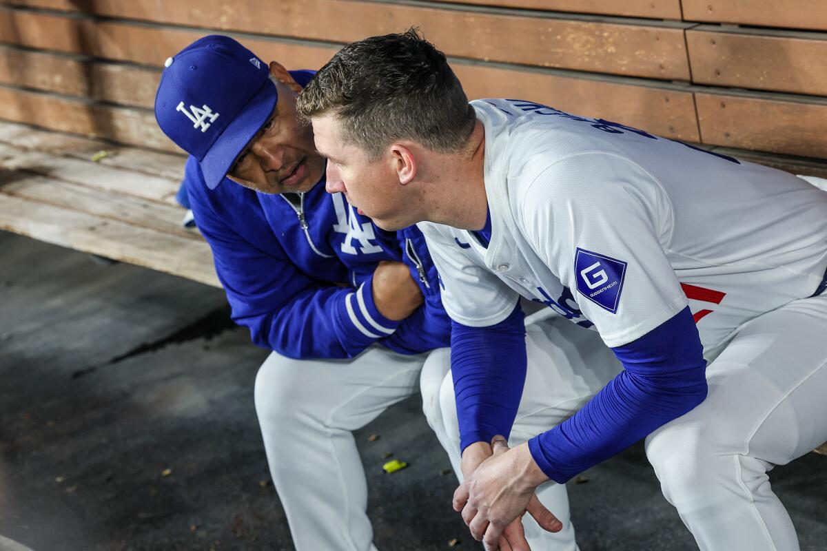 Dodgers manager Dave Roberts talks with pitcher Walker Buehler during a loss to the Colorado Rockies.