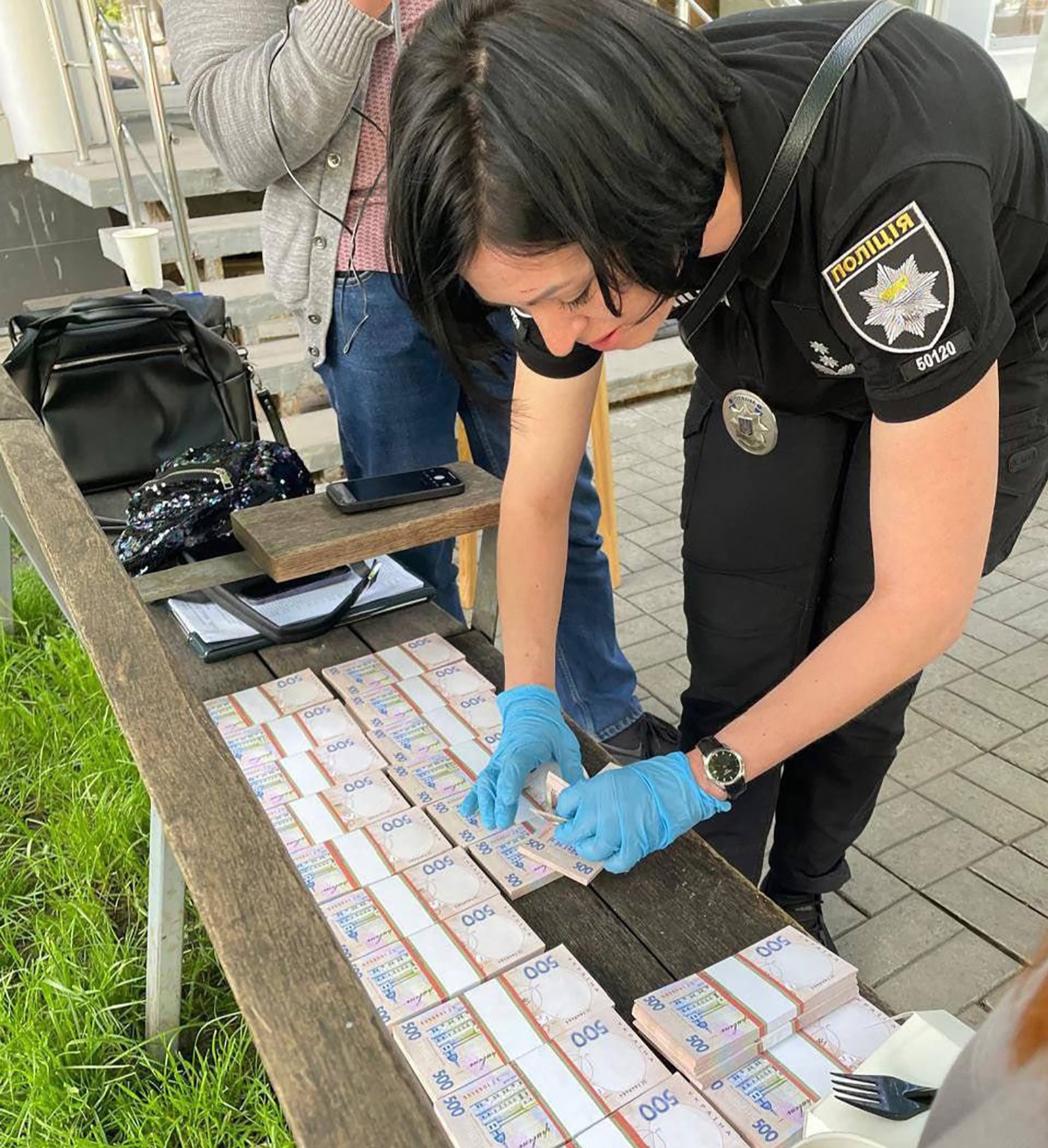 Here a police woman counts the cash found with the young mum