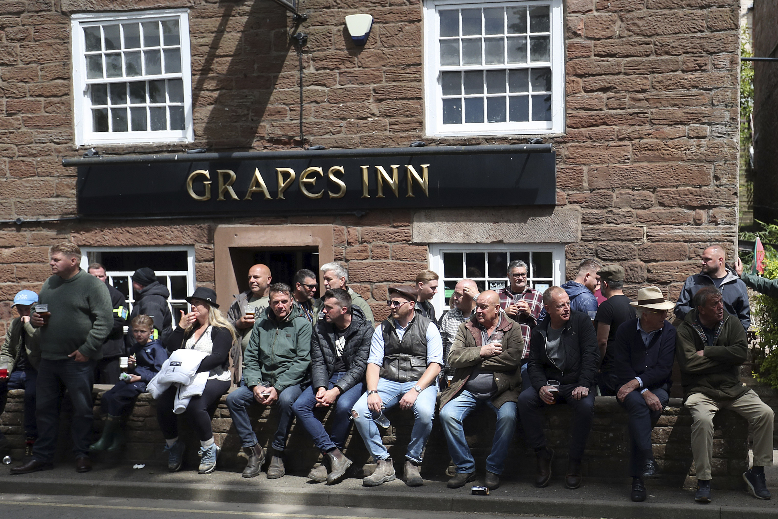 People sit outside a pub in Appleby-in-Westmorland, Cumbria