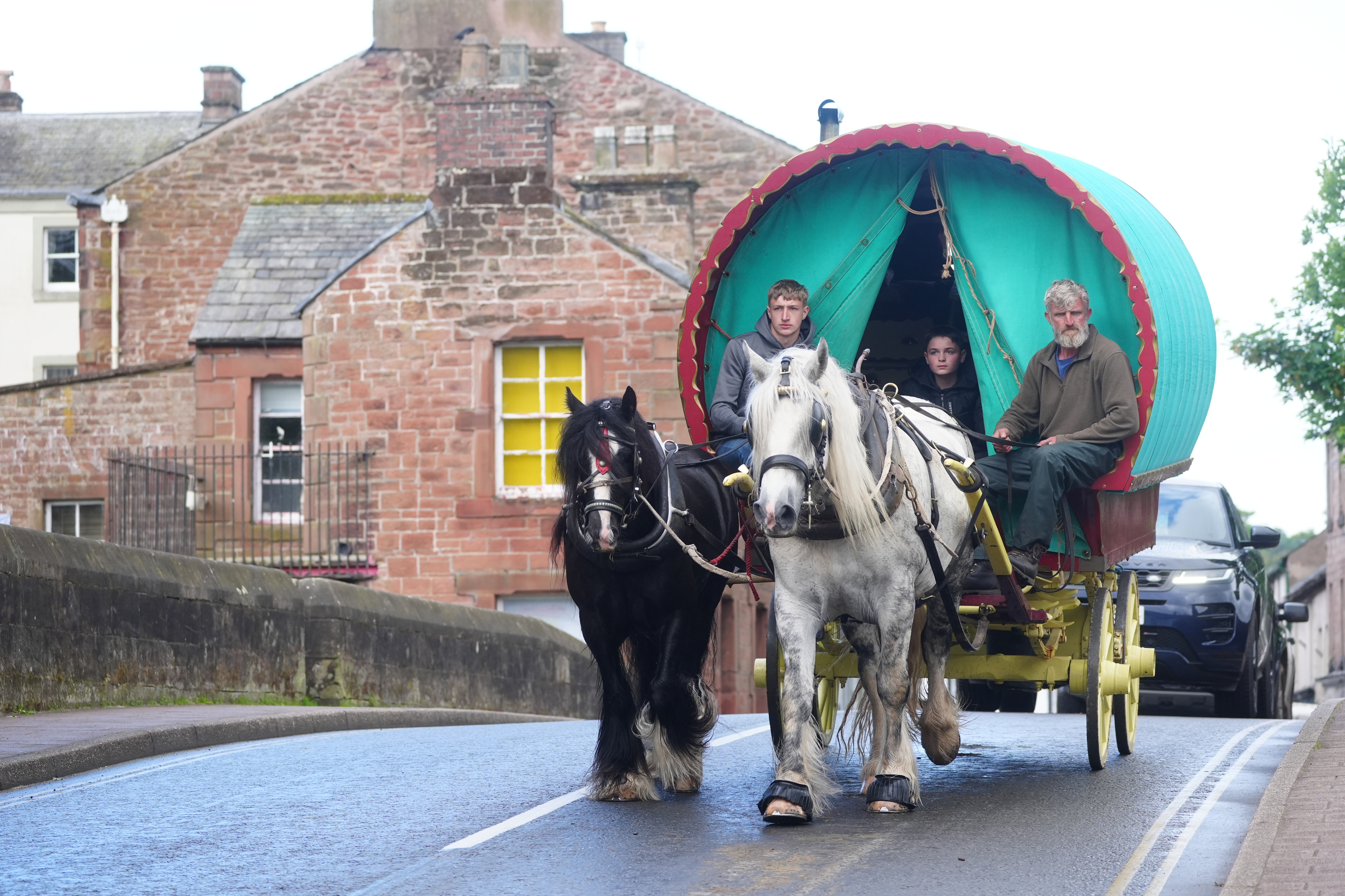 A group in a horse-drawn carriage arrive in Appleby for the fair