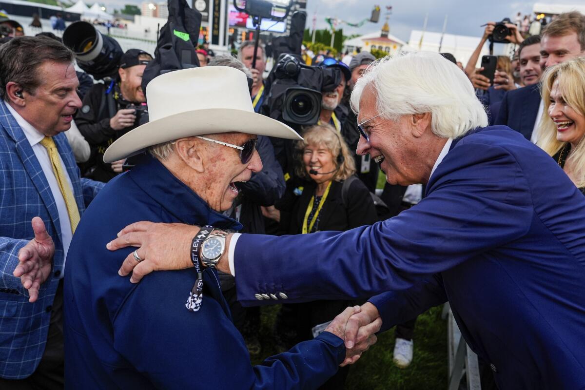 Seize The Grey trainer D. Wayne Lukas grins and shakes hands with with Bob Baffert after Lukas' horse won the Preakness