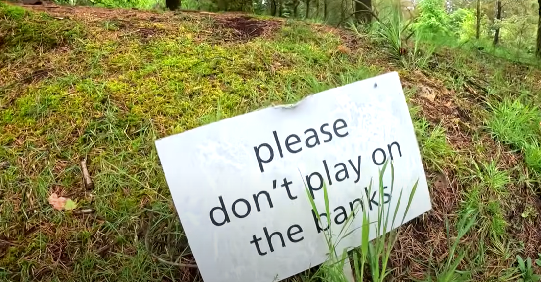 A sign warned against allowing kids playing on the grass banks
