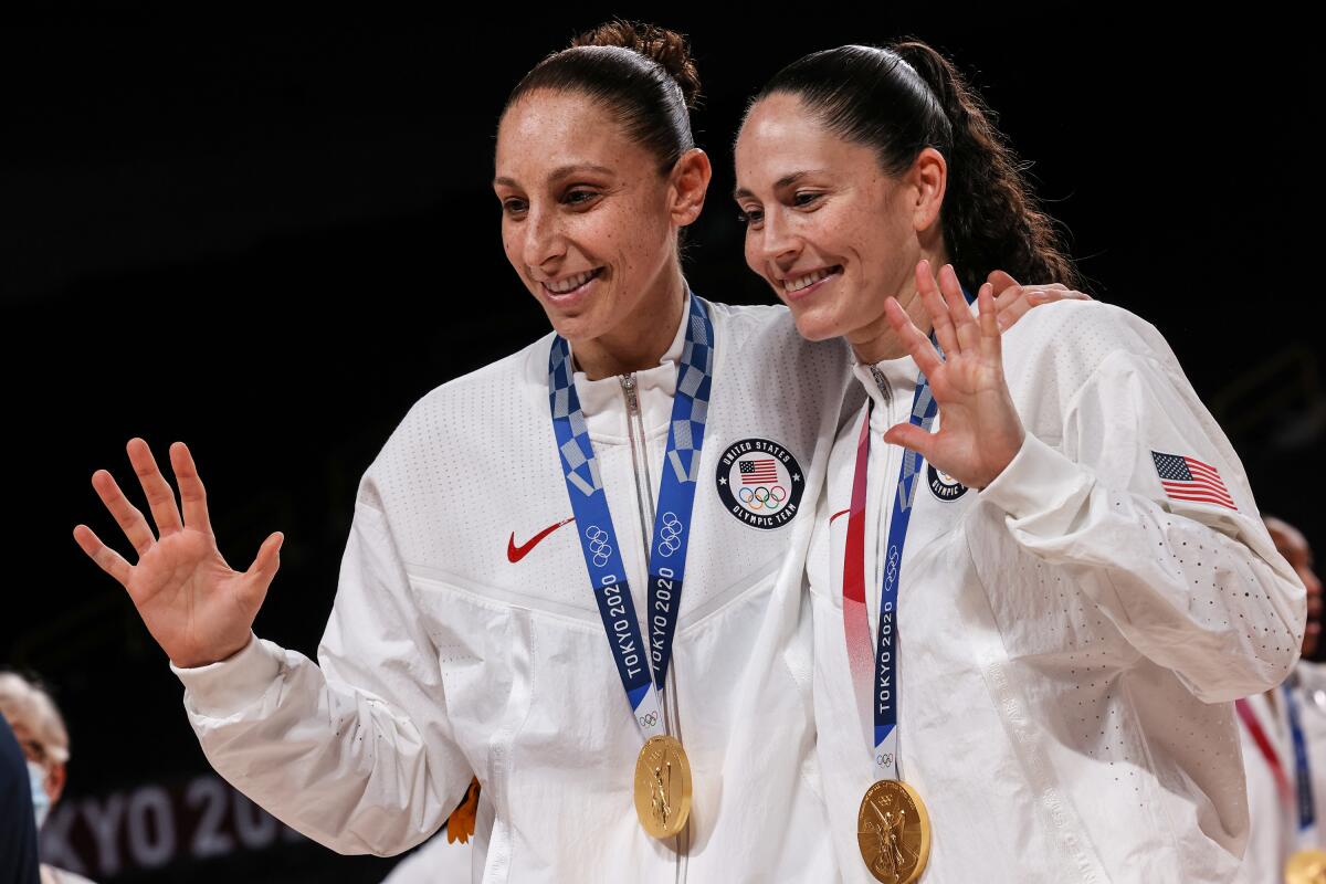 Diana Taurasi, left, and Sue Bird pose for photos after winning their fifth Olympic gold medals at the Tokyo Games.