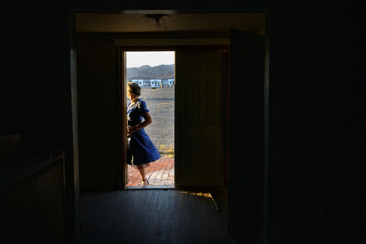 A woman in a dress stands in the doorway of the historic church.