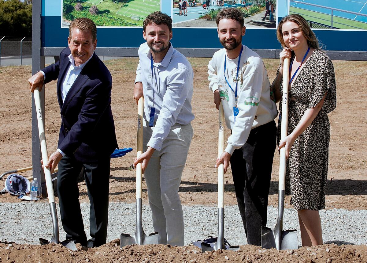 Doug Kimmelman and his children dig their shovels into the dirt at the May 8 groundbreaking.