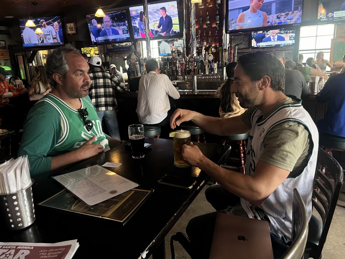 Two Celtics fans sit at a table in Sonny McLean's Irish Pub in Santa Monica