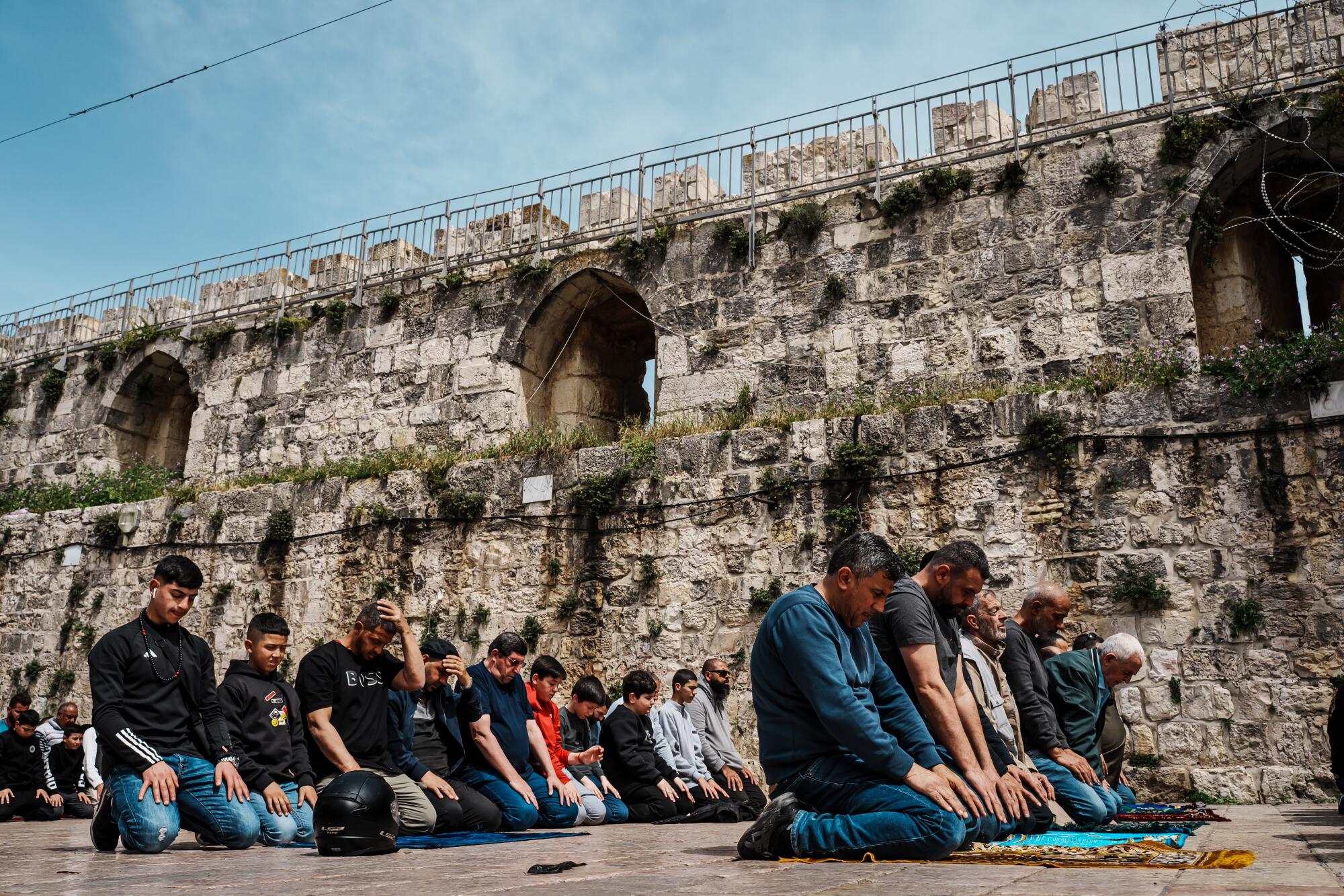 An overflow of worshippers make the Dhuhr afternoon prayers outside 