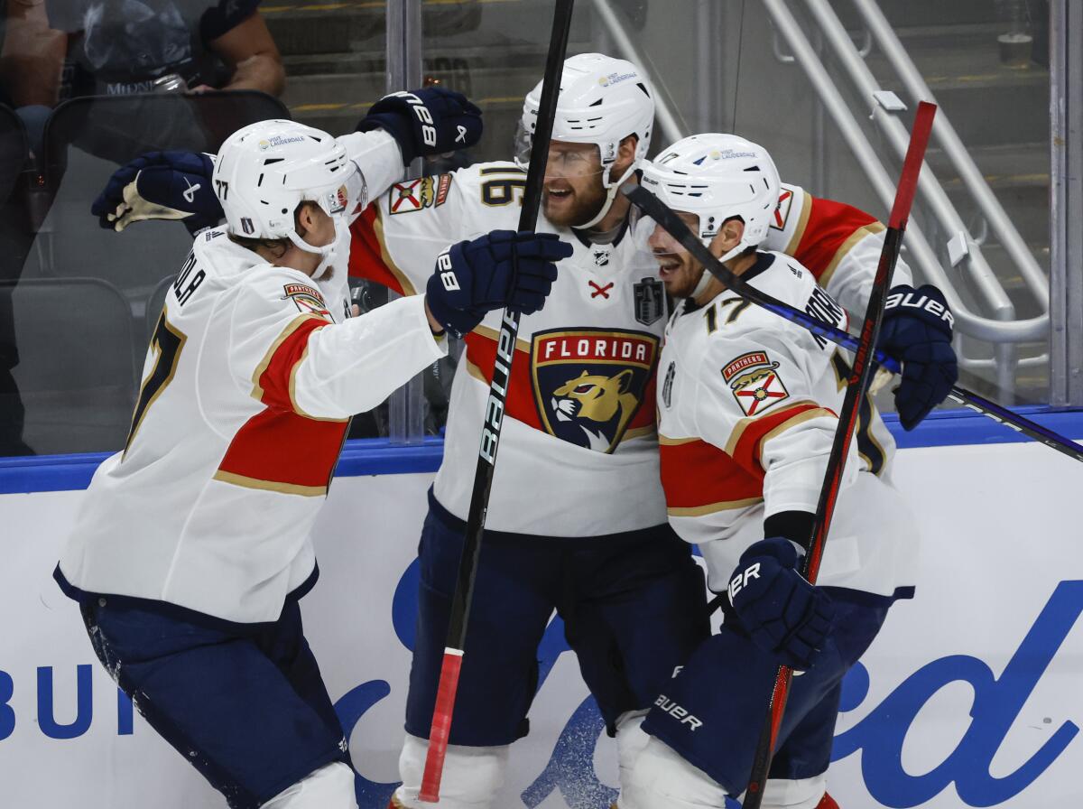 Panthers captain Aleksander Barkov, center, celebrates with Niko Mikkola, left, and Evan Rodrigues.