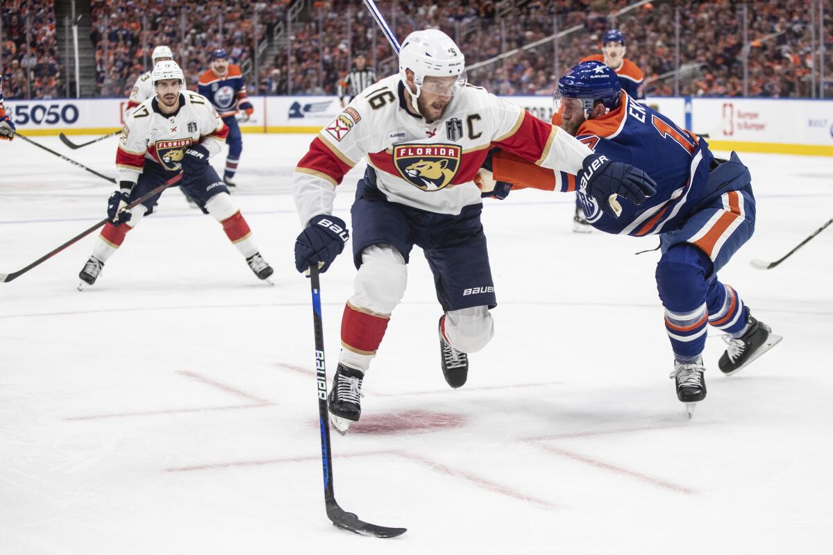 Florida captain Aleksander Barkov, left, and Edmonton Oilers defenseman Mattias Ekholm battle for the puck.