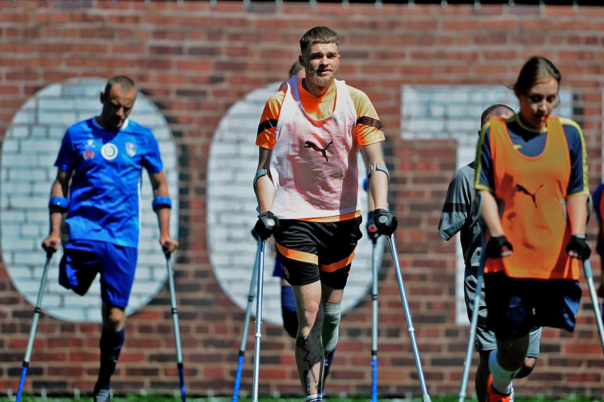 Oleksandr Kovalchuk, center, stands on the field with his FC Shakhtar teammates.