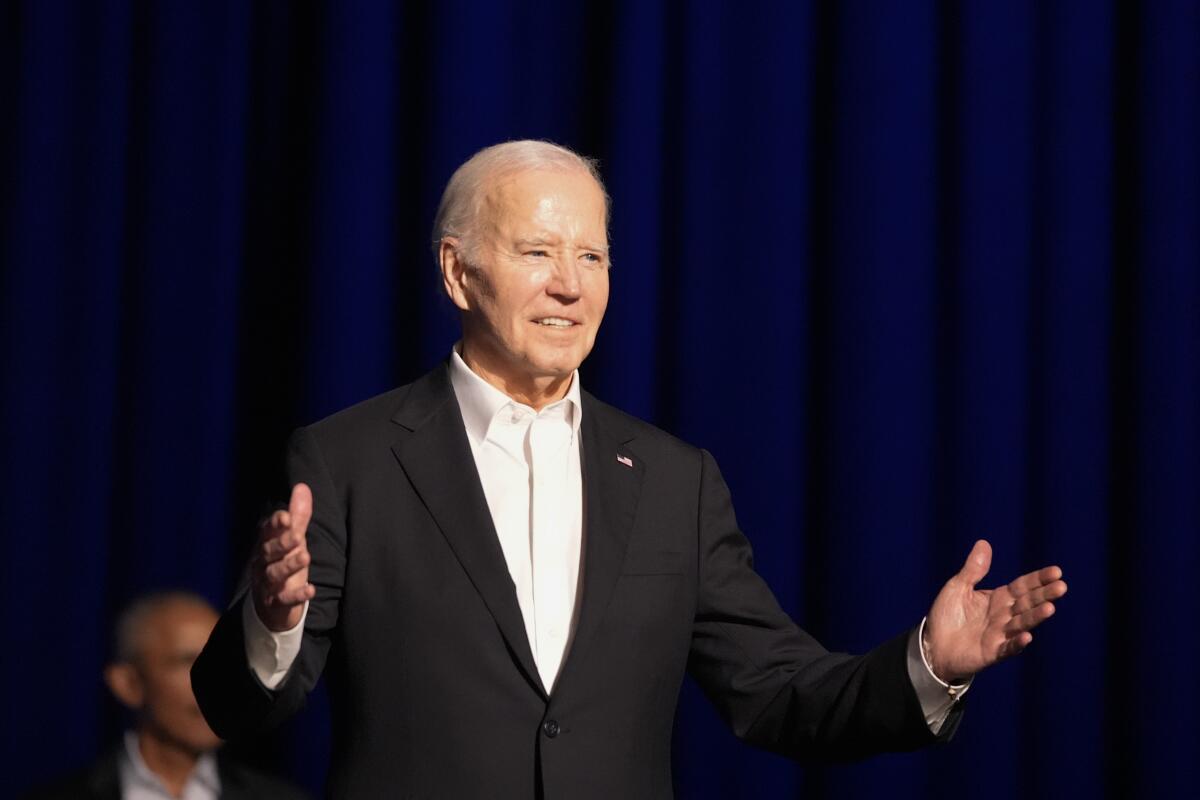 President Biden arrives onstage at Saturday night's Los Angeles fundraiser with former President Obama.