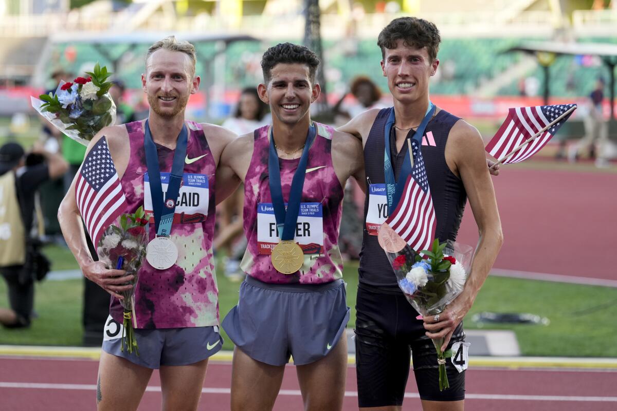 Grant Fisher, center, celebrates with second-place finisher Woody Kincaid, left, and third-place finisher Nico Young.