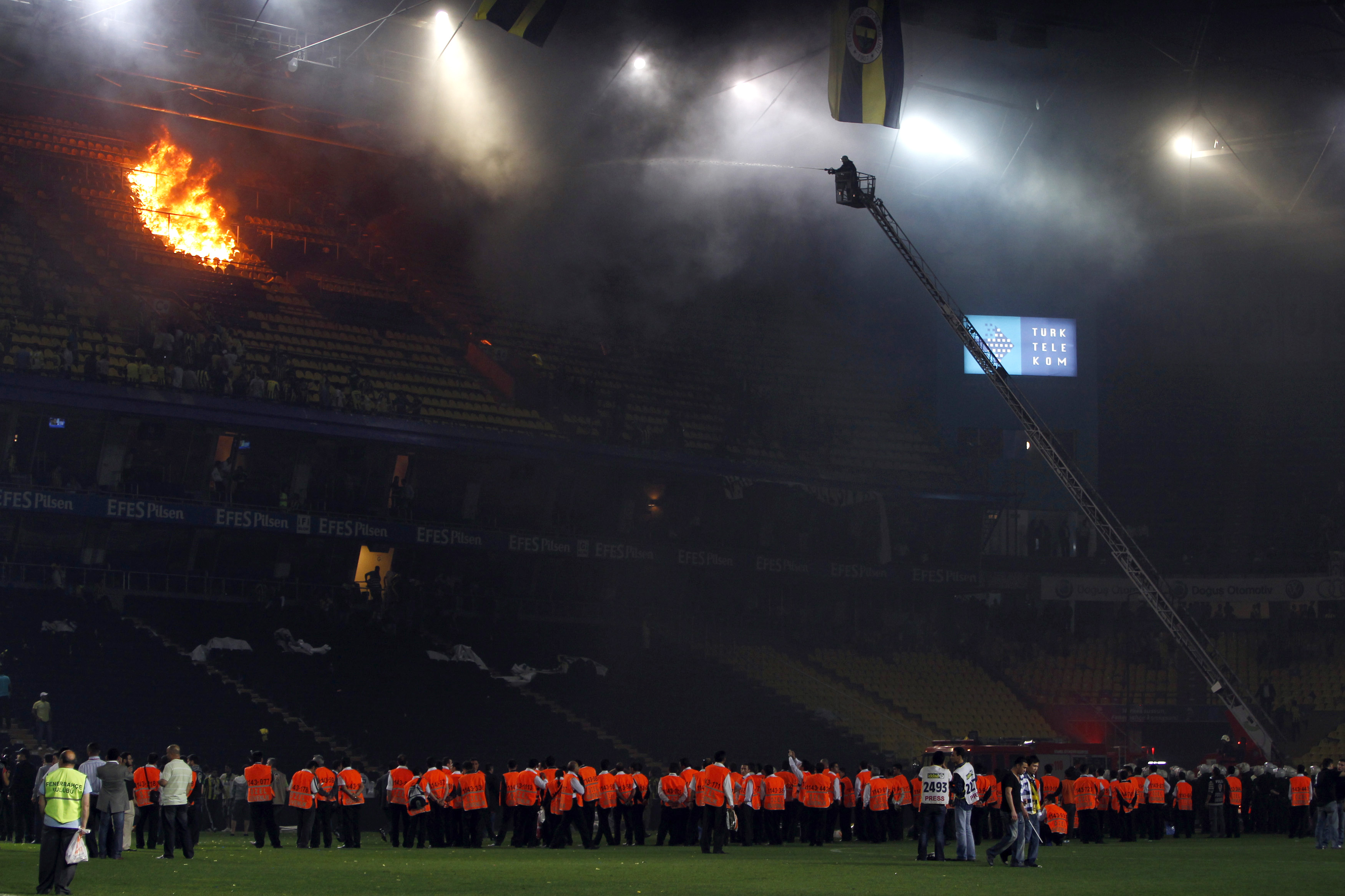 Firemen battle to put out the flames in the stadium after Turkish fans set fire to the stands