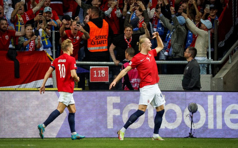 Two footballers celebrate goal.