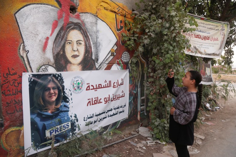 A Palestinian girl takes pictures at the scene where Al Jazeera reporter Shireen Abu Akleh was shot dead during an Israeli raid, in Jenin, in the Israeli-occupied West Bank, July 3, 2022.