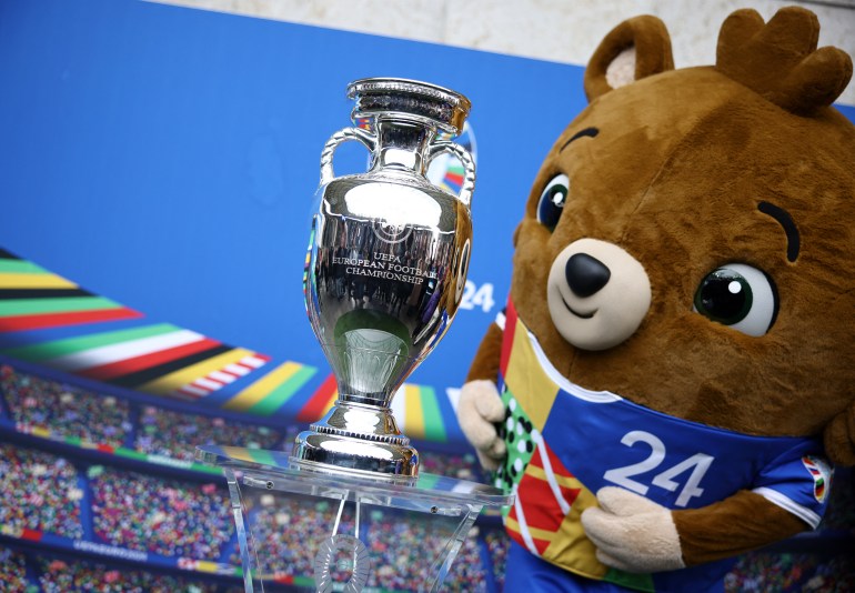 Tournament mascot holds trophy.