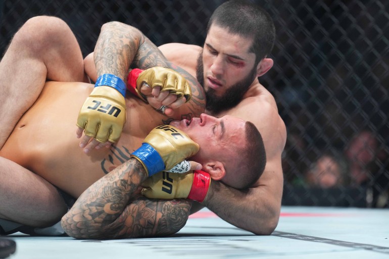 UFC fighter wrestles with opponent on the ground.