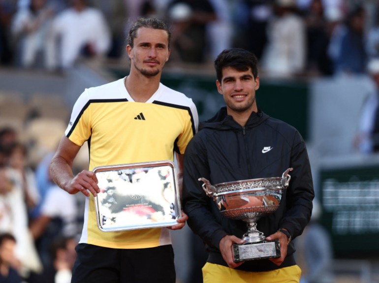 Tennis players parade trophies.