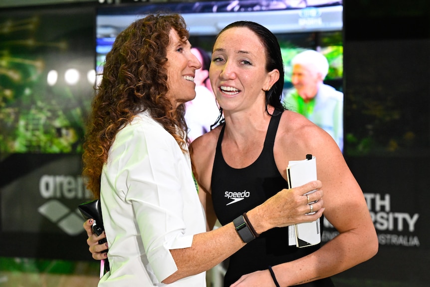 Swimmer Lani Pallister, wet and in her racing suit, embraces her mother Janelle Pallister after qualifying for the Olympics