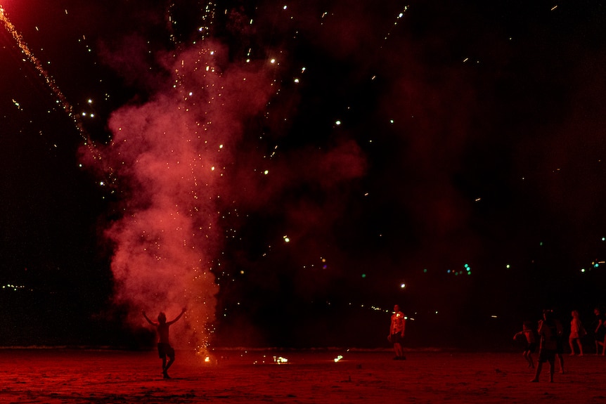 Mindil Beach is swarmed by people letting off fireworks from the sand.