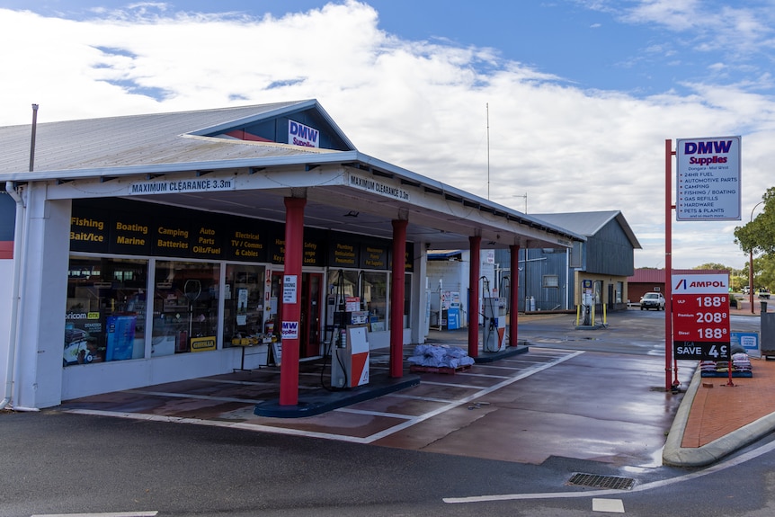 A man outside a general store and fuel pump in country Australia