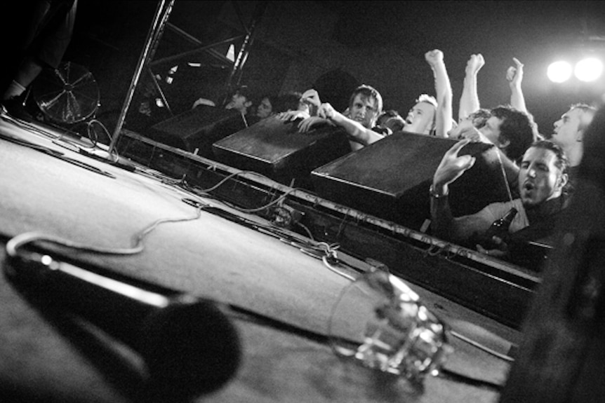 The Zoo crowd looking at the stage while a mic lays on the ground near the camera.