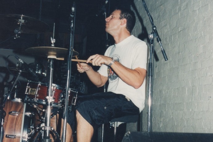 A man playing drums on stage.