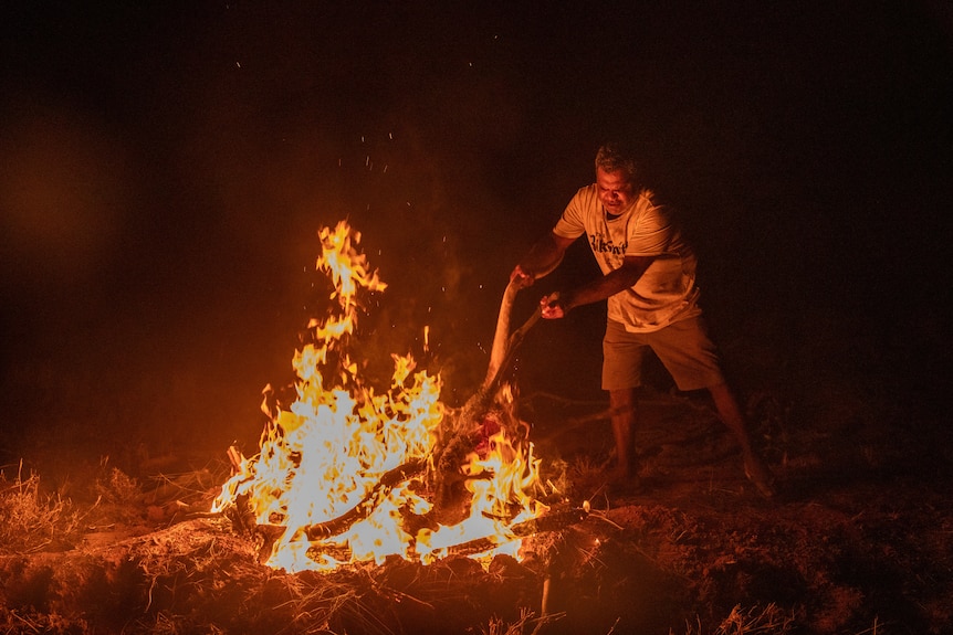 A man throws a kangroo into the fire 