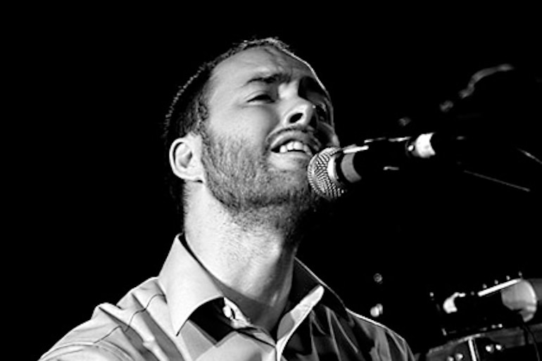 A singer on stage at The Zoo, playing piano.