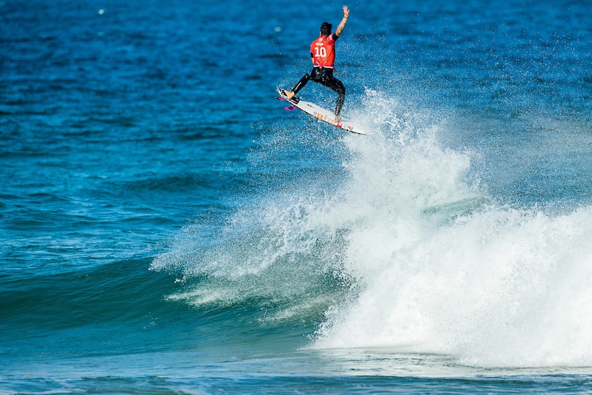 A Brazilian male surfer gets above a wave during a competition.