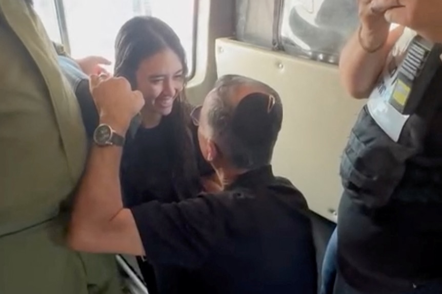 A young woman is seen embracing her father after being reunited.