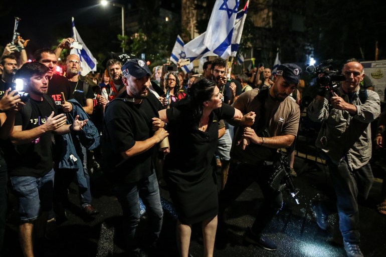 police arrest a young woman at a protest