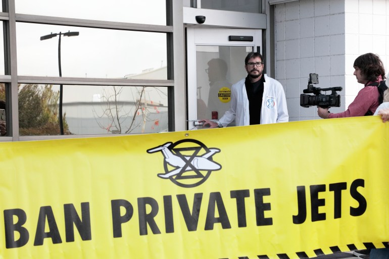 Joining a global day of action to ban private jets, Peter Kalmus and local activists chain shut the doors of a private airport in Charlotte, North Carolina, to underscore the disproportionately high impact the wealthy have in terms of carbon emissions. (2022)