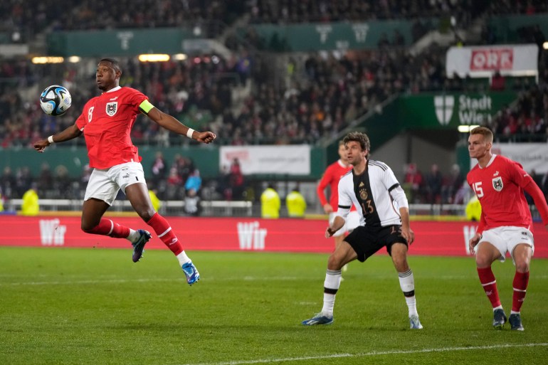 Player rises to head a football towards goal.