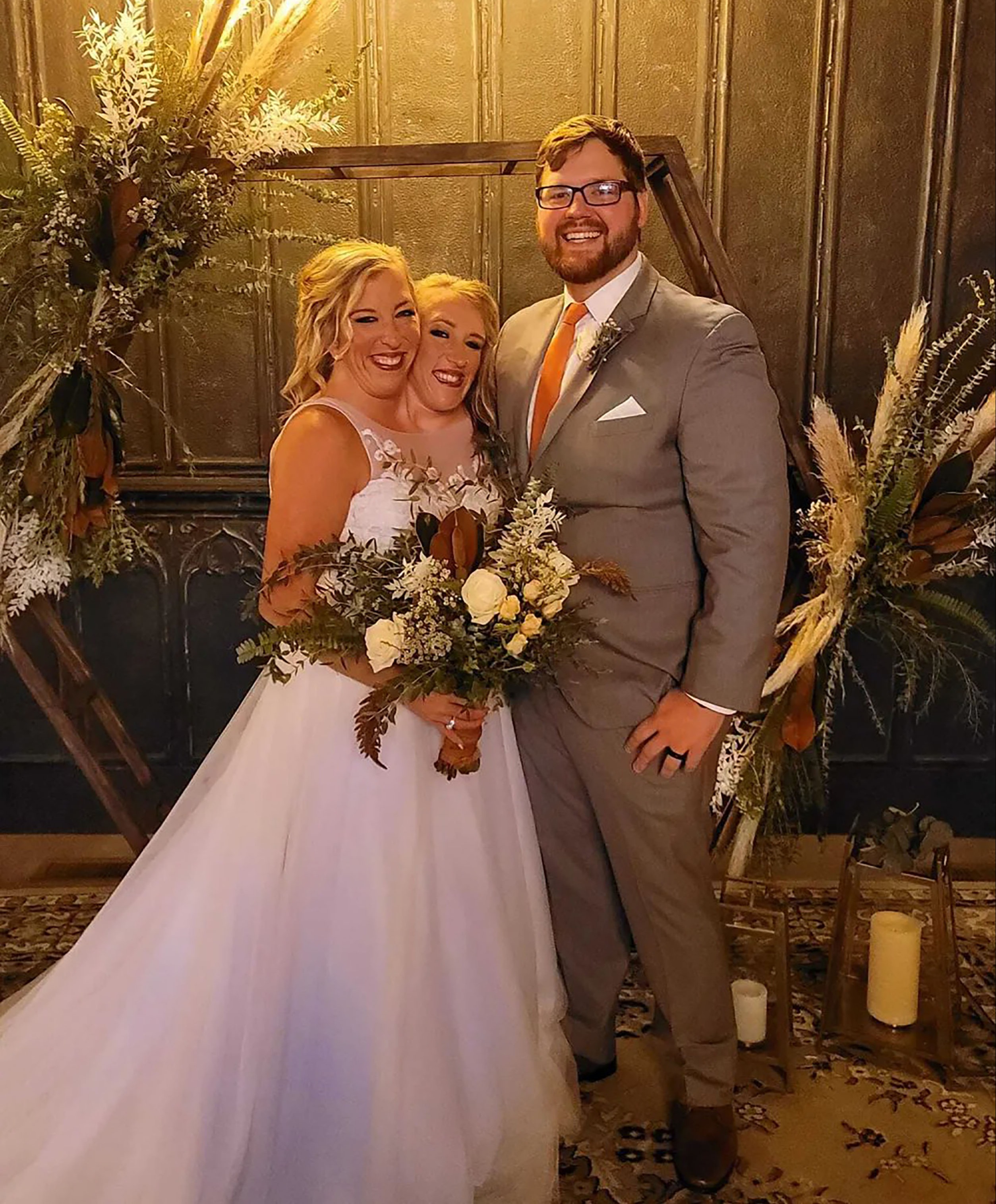 Abby Hensel (left) and her conjoined twin Brittany alongside husband Josh Bowling on her wedding day