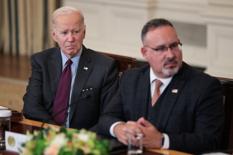 President Joe Biden and Secretary of the Department of Education Miguel Cardona seen listening during a meeting at White House in October 2022. On Thursday, a federal judge enjoined them from enforcing a new rule in four states that aimed at protecting LGBTQ students. File Photo by Oliver Contreras/UPI