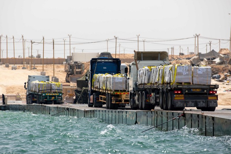 Trucks ferrying humanitarian assistance into Gaza from a temporary floating port began rolling again Thursday delivering approximately 656 metric tons (1.4 million pounds) of supplies onto the beach, the largest single day delivery of aid to date. The deliveries resumed after a week-long disruption due to bad weather. File Photo via U.S. Army/UPI