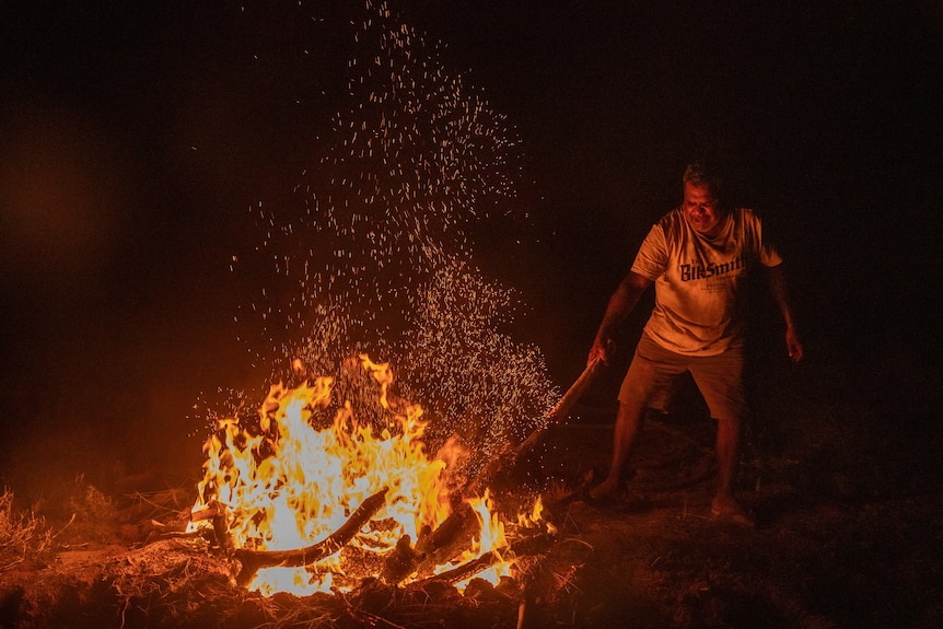 A man puts a kangaroo into the fire. 