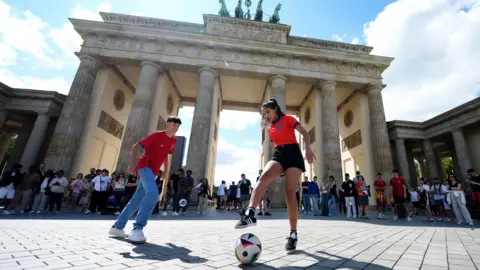 PA Media English fan plays football with a Spanish fan in Berlin