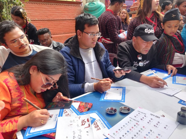 Lalima Shrestha (left) and Suyogya Ratna Tamrakar (next to Lalima) at the live calligraphy session