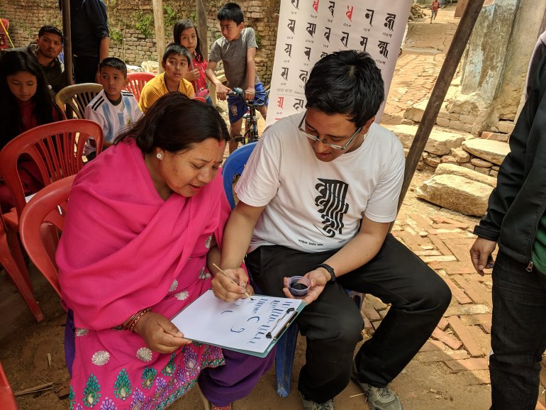 Suyogya Tamrakar assists Ranjana Lipi learners