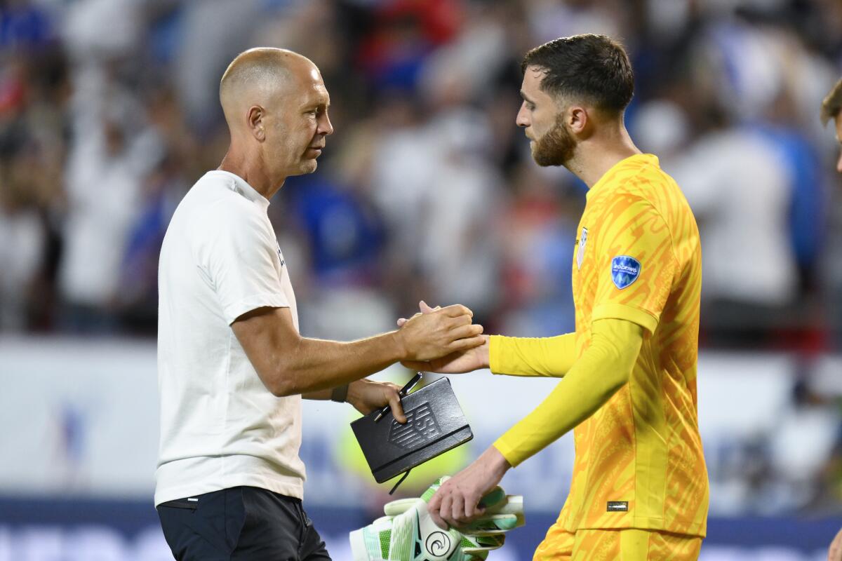 Gregg Berhalter shakes hands with Matt Turner.