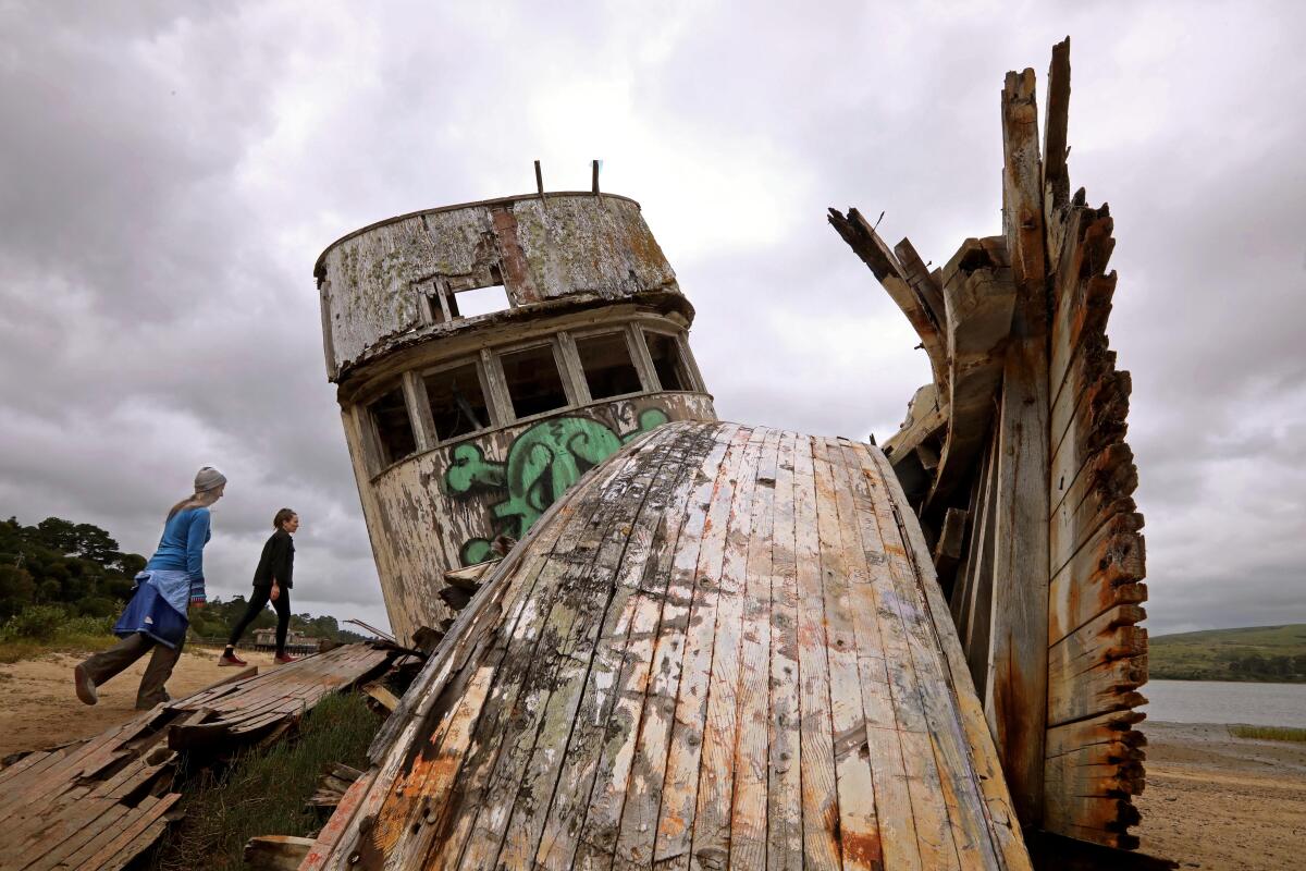 The Inverness Shipwreck in Inverness, California. A wooden ship rests upon the beach.