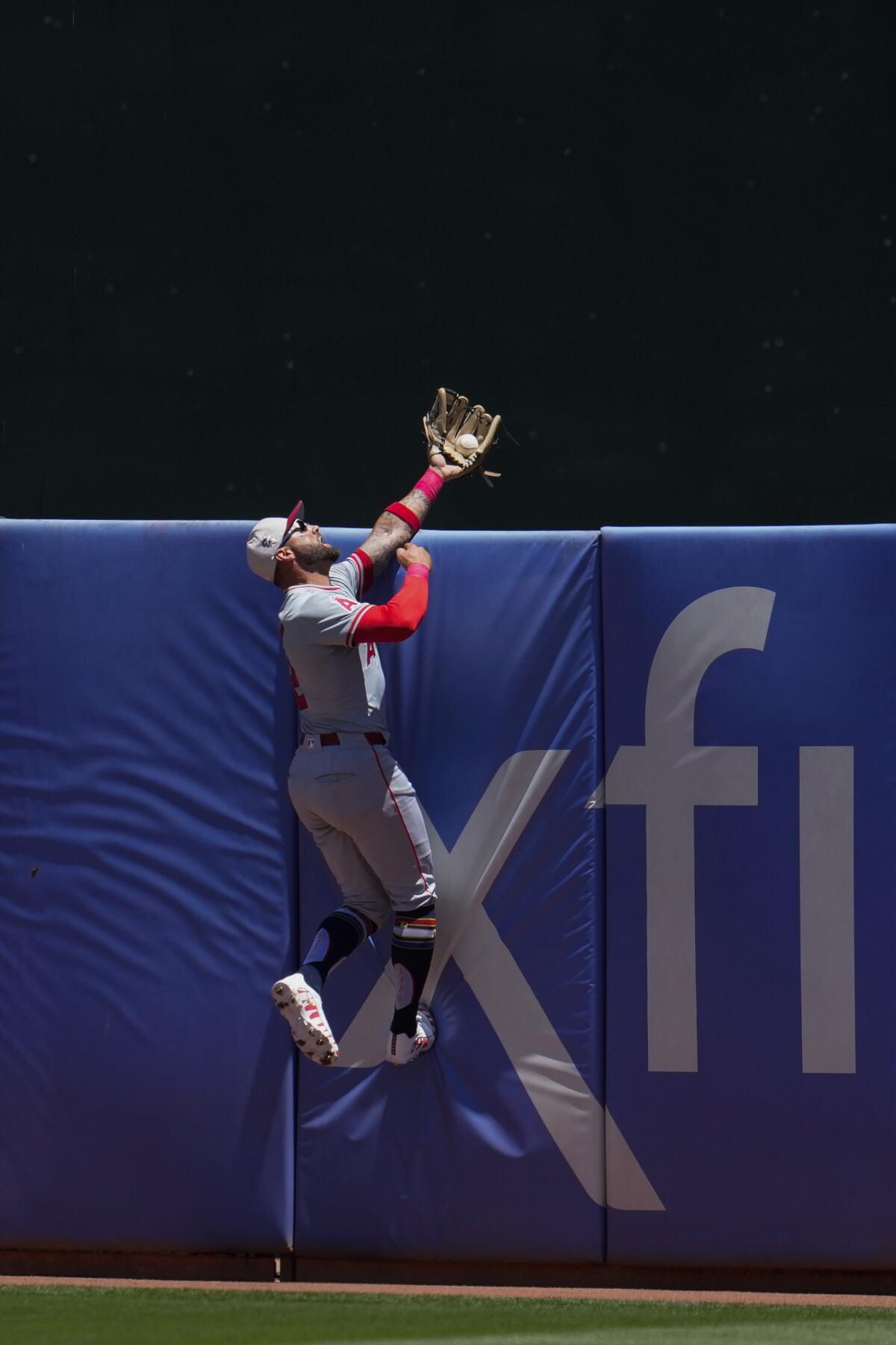 Angels center fielder Kevin Pillar leaps against a blue center field wall to rob JJ Bleday of a home run