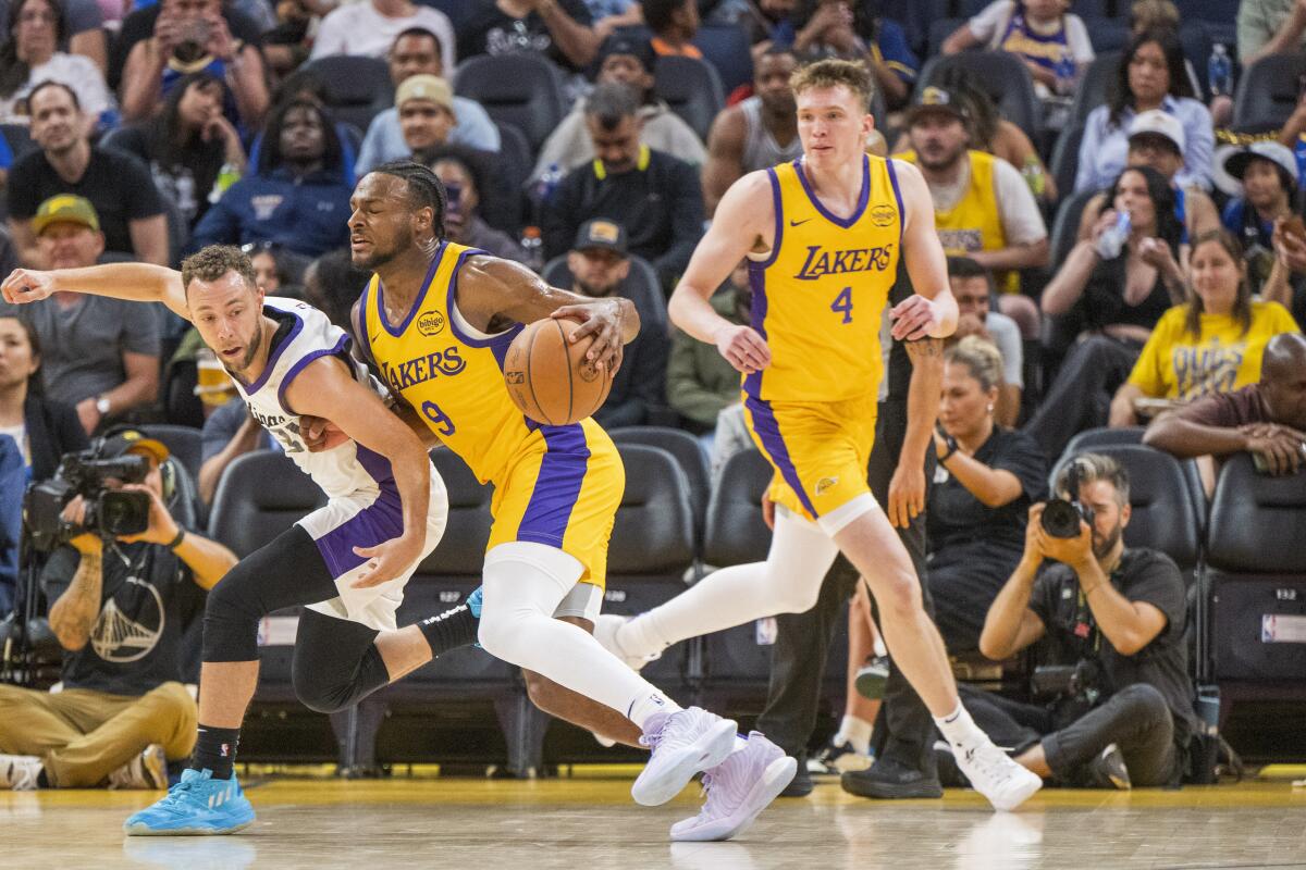 Lakers guard Bronny James, center, drives against Kings guard Jordan Ford, left, as Lakers teammate Dalton Knecht watches.